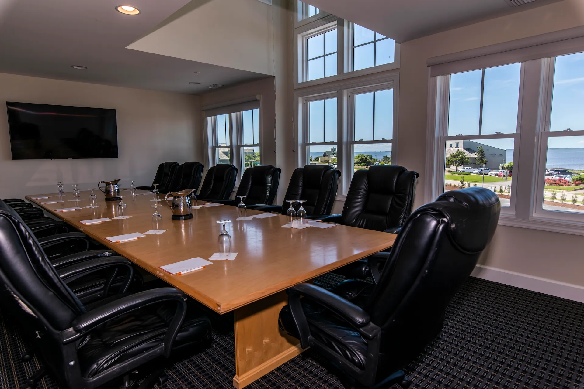 Interior of The Event House Corbell Executive Boardroom, showcasing a spacious layout with a large conference table and modern office chairs.